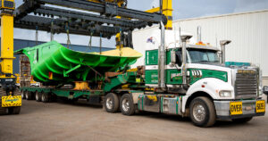 Performance Minaría's distinctive green Hercules caja de camión siendo cargados por CombiLift onto truck leaving Schlam's Forrestfield facility